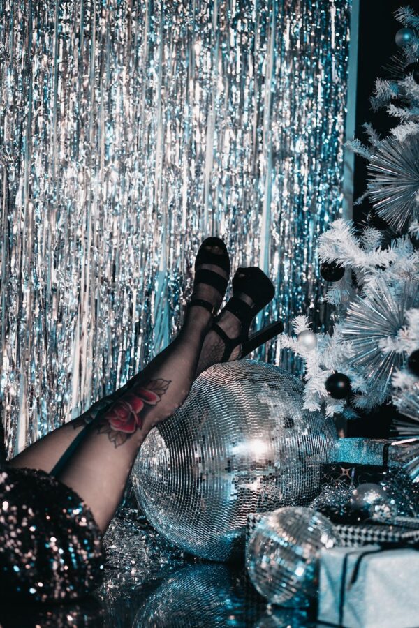 woman in high heels resting her legs on a disco ball