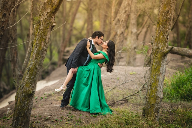 week 116 header image- man and woman dressed in green, embracing in forest